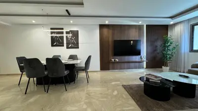 a living room with a table and chairs and a television at Garden View and Terrace 3BR - AppartAli Luxury Platform in Casablanca