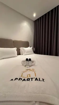 a hotel room with a white bed with two remote controls at Dreamy 3BR with Terrace -AppartAli Luxury Platform in Casablanca