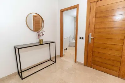 a hallway with a mirror and a table and a door at 7th Floor 3BR with Terrace - AppartAli Luxury Platform in Casablanca