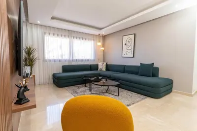 a living room with a green couch and a yellow chair at 7th Floor 3BR with Terrace - AppartAli Luxury Platform in Casablanca