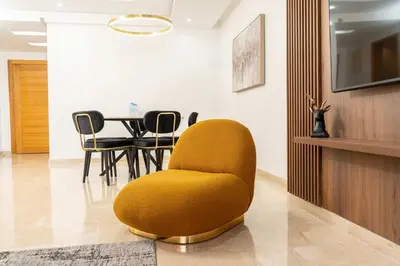 a living room with a yellow chair and a table at 7th Floor 3BR with Terrace - AppartAli Luxury Platform in Casablanca
