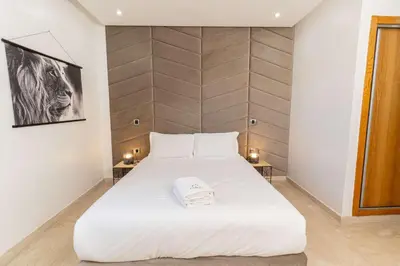 a large white bed in a room with two tables at 7th Floor 3BR with Terrace - AppartAli Luxury Platform in Casablanca