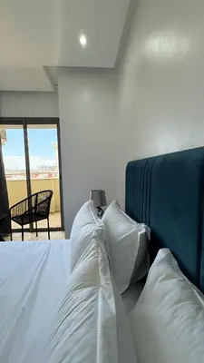 a bedroom with a bed with white sheets and pillows at 7th Floor 3BR with Terrace - AppartAli Luxury Platform in Casablanca