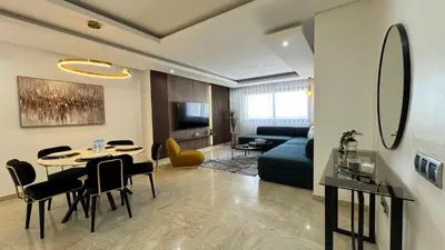 a living room with a table and a blue couch at 7th Floor 3BR with Terrace - AppartAli Luxury Platform in Casablanca