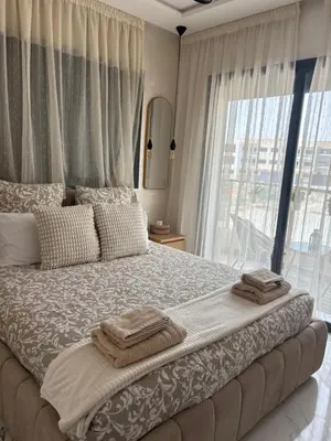 a bedroom with a large bed with towels on it at Cosy appartement lumineux Awards 2026 in Bouznika