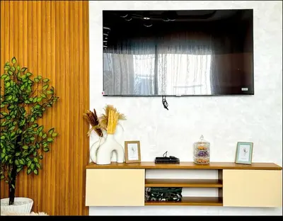 a entertainment center with a television on a wall at Cosy appartement lumineux Awards 2026 in Bouznika
