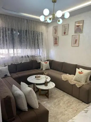 a living room with a couch and a table at Cosy appartement lumineux Awards 2026 in Bouznika