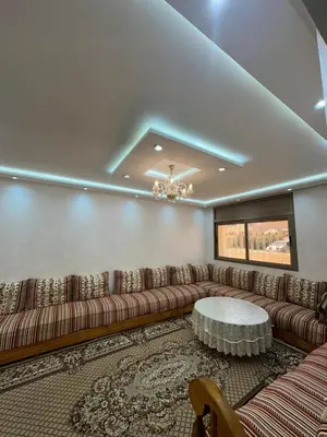a living room with a large couch and a table at Villa à Harhoura in Temara