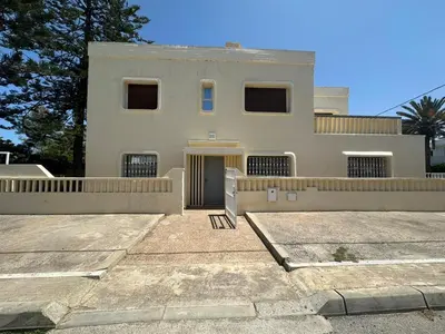 a large white house with a fence in front of it at Villa à Harhoura in Temara