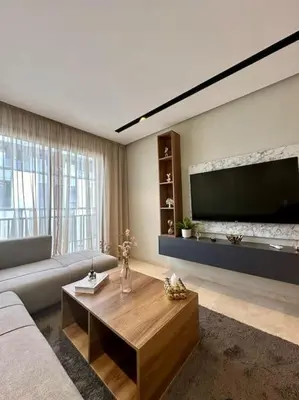 a living room with a couch and a large flat screen tv at Studio Lilas CFC in Casablanca