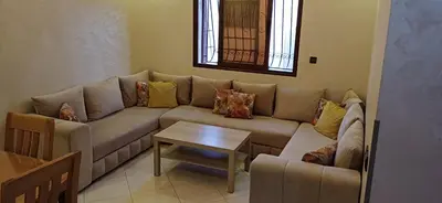 a living room with a couch and a table at Appartement très propre et calme in Bouznika