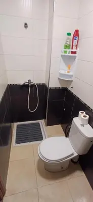 a bathroom with a shower with a toilet and a drain at Appartement très propre et calme in Bouznika