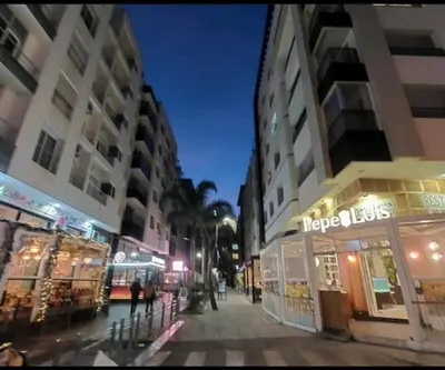 a city street at night with shops and buildings at Downtown apartment in Casablanca