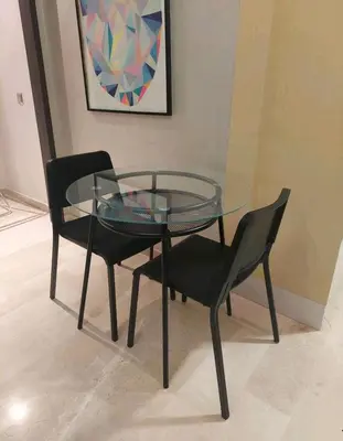 a glass table with two black chairs and a glass table and chairs at Downtown apartment in Casablanca