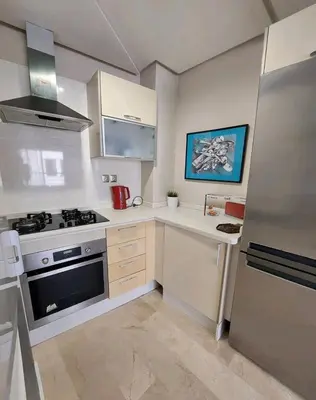 a white kitchen with a stove and a refrigerator at Downtown apartment in Casablanca