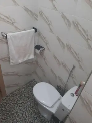 a bathroom with a white toilet and a towel at Espace de détente in Bouznika