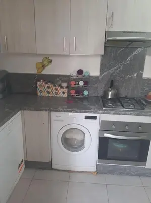 a kitchen with a washing machine and a stove at Espace de détente in Bouznika