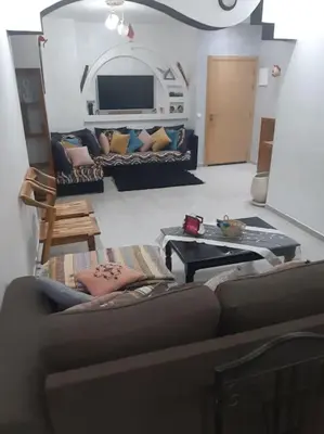 a living room with a couch and a table at Espace de détente in Bouznika