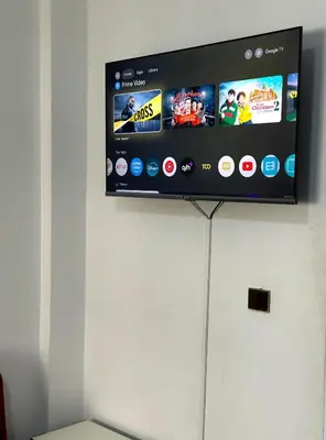 a flat screen tv on top of a white refrigerator at Appartement 5 min à gare Bouskoura & Hôpital Mohamed 6 in Bouskoura