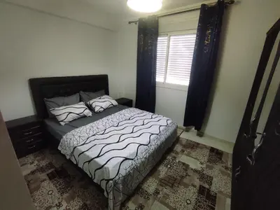 a bedroom with a bed and a window at Appartement 5 min à gare Bouskoura & Hôpital Mohamed 6 in Bouskoura