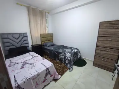 a bedroom with two beds and a dresser at Appartement 5 min à gare Bouskoura & Hôpital Mohamed 6 in Bouskoura