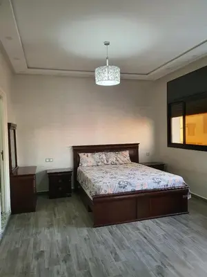 a bedroom with a bed and a chandelier at Villa entière in Azemmour