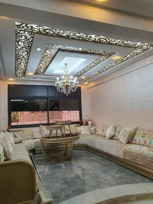 a living room with a large couch and a chandelier at Villa entière in Azemmour