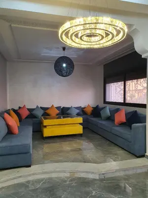 a living room with a couch and a chandelier at Villa entière in Azemmour