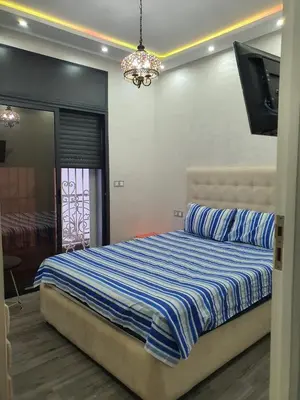 a bedroom with a bed and a flat screen tv at Villa entière in Azemmour