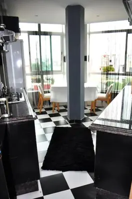 a kitchen with a black and white checkered floor at Appartement a louer Harhoura in Temara