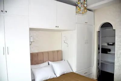 a bedroom with a bed and white cabinets at Appartement a louer Harhoura in Temara