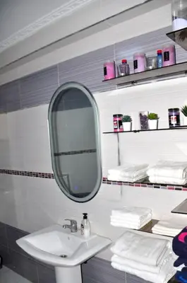 a bathroom with a sink and a mirror and towels at Appartement a louer Harhoura in Temara