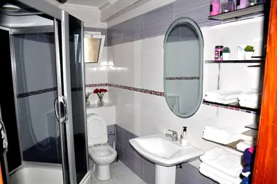 a bathroom with a sink and a toilet and a mirror at Appartement a louer Harhoura in Temara