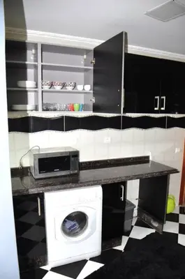 a kitchen with a washing machine on a counter at Appartement a louer Harhoura in Temara