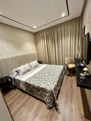 a bedroom with a bed and a desk and a television at Studio Eucalyptus CFC n 16 in Casablanca