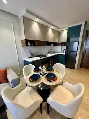 a living room with a table and chairs and a kitchen at Studio Eucalyptus CFC n 16 in Casablanca