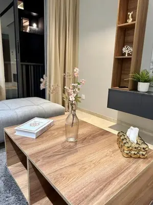 a vase of flowers on a wooden table in a living room at Studio Jasmin CFC n 15 in Casablanca