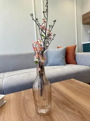 a glass vase with flowers sitting on a table at Studio lotus CFC n 21 in Casablanca