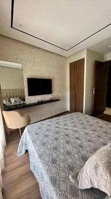 a bedroom with a large bed and a television at Studio Vénus CFC n 22 in Casablanca