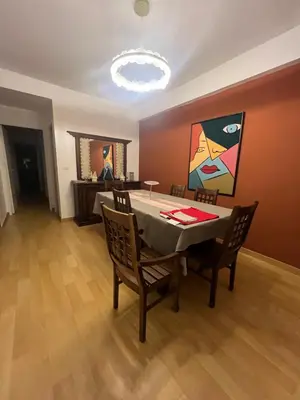a dining room with a table with chairs and a painting at Magnifique appartement maarif in Casablanca