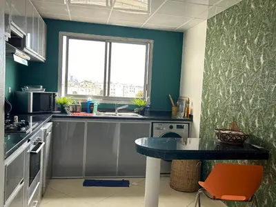 a small kitchen with a table and a window at Magnifique appartement maarif in Casablanca