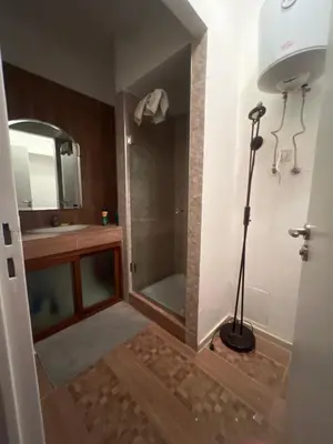 a bathroom with a shower and a mirror and a lamp at Magnifique appartement maarif in Casablanca