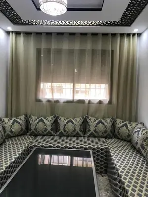 a large couch in a living room with a window at Bel appartement de plage - RDC - Dahomey Beach in Bouznika