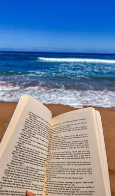 an open book laying on a beach with the ocean at Bel appartement de plage - RDC - Dahomey Beach in Bouznika