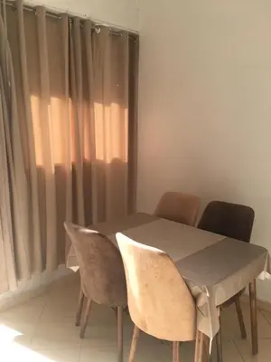a dining room table with four chairs and a window at Mohammed V Airport Appartement in Deroua