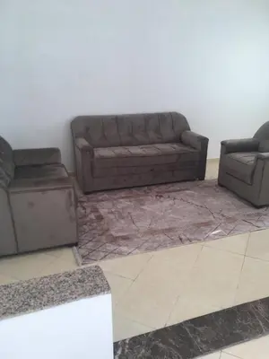 a living room with a brown couch and two couches at Mohammed V Airport Appartement in Deroua