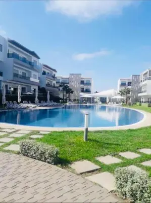 a large swimming pool in the middle of a city at 2 bedroom appart at the beach in gated community with pool in Sidi Rahal
