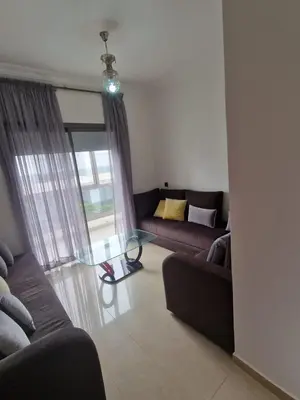 a living room with two couches and a glass table at 2 bedroom appart at the beach in gated community with pool in Sidi Rahal