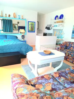 a bedroom with a bed and a table and a couch at Skhirat terrace apartment at the beach in Skhirat