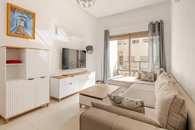 a living room with a couch and a tv at Studio Élégant avec piscine à Zenata Eco city in Aïn Harrouda